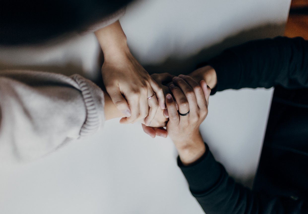 Two people grasping hands over a table