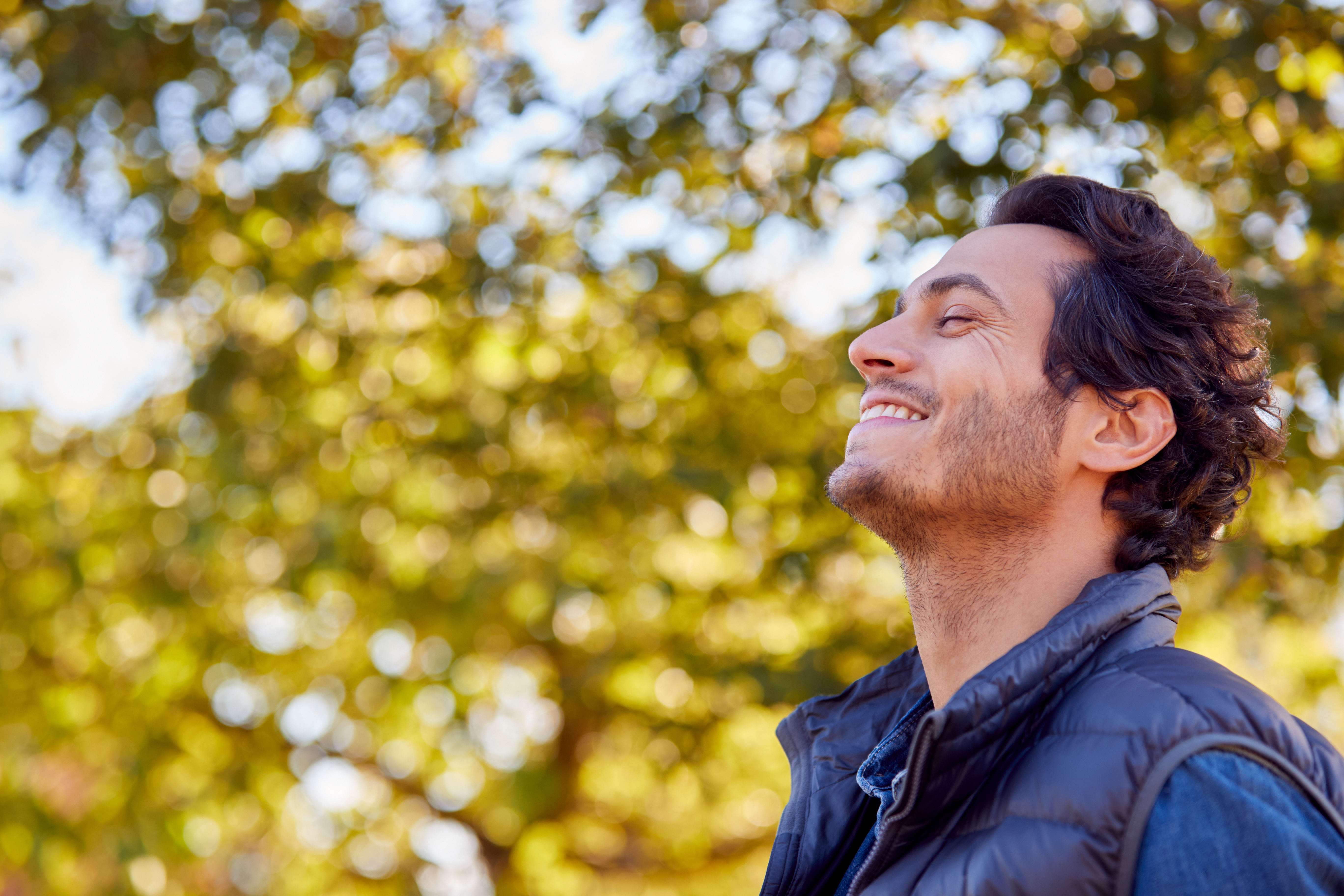 Man smiling with eyes closed and faced turned up
